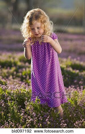 Stock Image - Caucasian girl picking flowers. Fotosearch