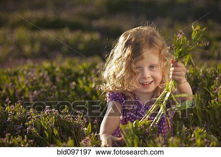 Stock Photo - Caucasian girl picking flowers. Fotosearch