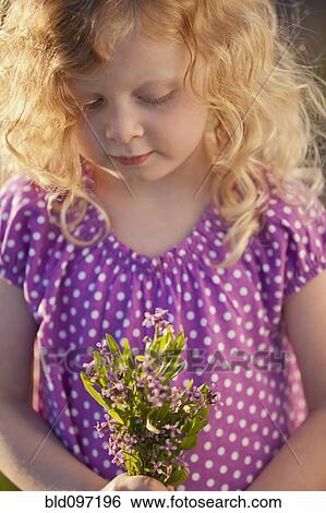 Stock Photograph - Caucasian girl picking flowers. Fotosearch