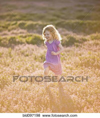 Caucasian girl running through field of flowers View Large Photo Image Stock Photo - Caucasian girl running through field of flowers. Fotosearch