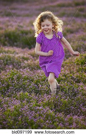 Stock Photo - Caucasian girl running through field of flowers. Fotosearch