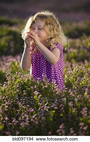 Picture - Caucasian girl smelling flowers. Fotosearch