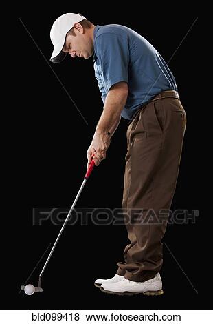 Stock Photo - Caucasian golfer putting golf ball. Fotosearch