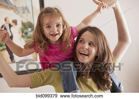 Caucasian mother carrying daughter on her shoulders View Large Photo Image Stock Photo - Caucasian mother carrying daughter on her shoulders. Fotosearch