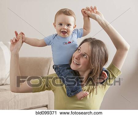 Caucasian mother carrying son on her shoulders View Large Photo Image Stock Image - Caucasian mother carrying son on her shoulders. Fotosearch