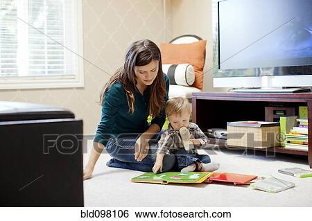 Stock Photograph - Caucasian mother reading book to son. Fotosearch