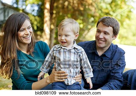 Caucasian parents sitting outdoors with son View Large Photo Image Stock Photo - Caucasian parents sitting outdoors with son. Fotosearch