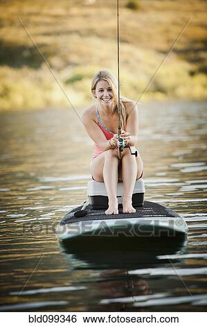 Stock Photograph - Caucasian woman fishing in lake. Fotosearch