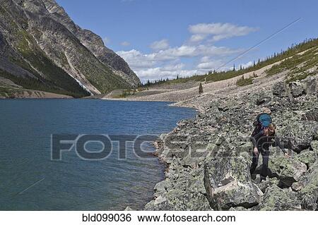 Stock Photograph - Caucasian woman hiking near lake. Fotosearch