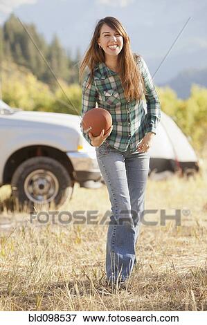 Stock Photo - Caucasian woman holding football. Fotosearch