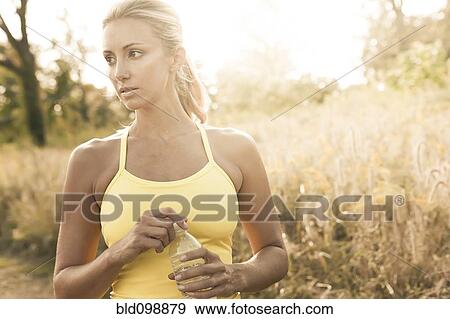 Caucasian woman holding water bottle outdoors View Large Photo Image Stock Photo - Caucasian woman holding water bottle outdoors. Fotosearch