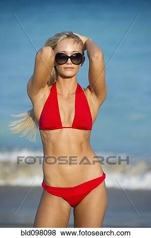 Stock Photo - Caucasian woman in bikini standing on beach. Fotosearch