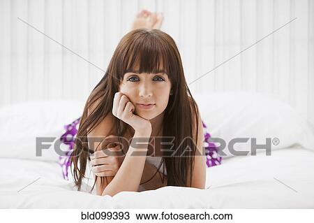 Caucasian woman laying on bed View Large Photo Image Stock Image - Caucasian woman laying on bed. Fotosearch