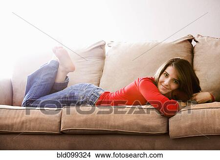 Picture - Caucasian woman laying on sofa. Fotosearch
