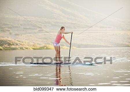 Stock Photo - Caucasian woman on stand up paddle board. Fotosearch