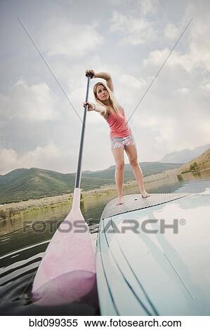 Stock Photography - Caucasian woman on stand up paddle board. Fotosearch