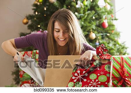 Caucasian woman opening Christmas gift View Large Photo Image Stock Photography - Caucasian woman opening Christmas gift. Fotosearch