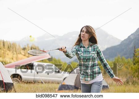 Caucasian woman playing badminton at campsite View Large Photo Image Stock Photo - Caucasian woman playing badminton at campsite. Fotosearch