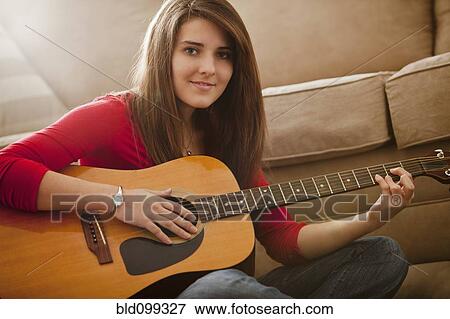 Stock Photo - Caucasian woman playing guitar. Fotosearch