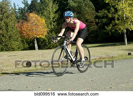 Stock Photograph - Caucasian woman riding bicycle in park. Fotosearch