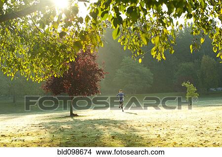 Picture - Caucasian woman running in park. Fotosearch