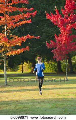 Stock Image - Caucasian woman running in park. Fotosearch