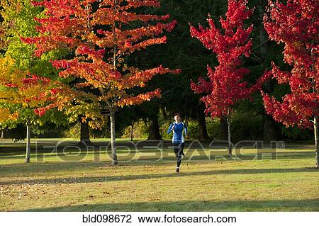 Stock Image - Caucasian woman running in park. Fotosearch