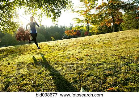 Stock Photo - Caucasian woman running in park. Fotosearch