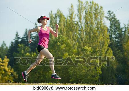Stock Photo - Caucasian woman running in park. Fotosearch