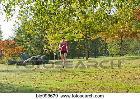 Caucasian woman running in park View Large Photo Image Stock Photo - Caucasian woman running in park. Fotosearch