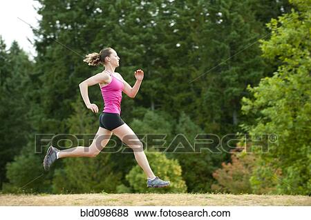 Caucasian woman running in park View Large Photo Image Stock Photo - Caucasian woman running in park. Fotosearch