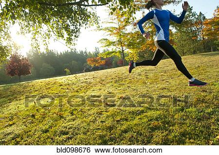 Stock Photograph - Caucasian woman running in park. Fotosearch