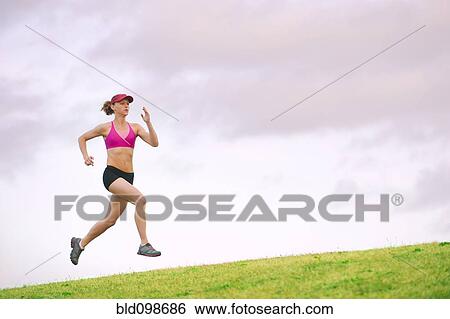 Stock Photograph - Caucasian woman running in park. Fotosearch