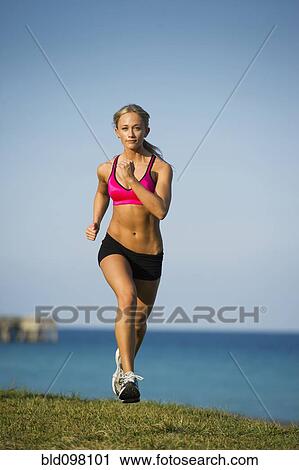 Caucasian woman running near ocean View Large Photo Image Stock Image - Caucasian woman running near ocean. Fotosearch