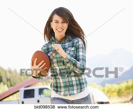 Stock Photo - Caucasian woman running with football. Fotosearch