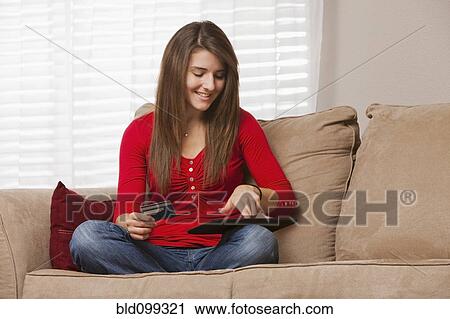 Stock Image - Caucasian woman shopping online using digital tablet. Fotosearch