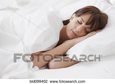 Stock Image - Caucasian woman sleeping in bed. Fotosearch