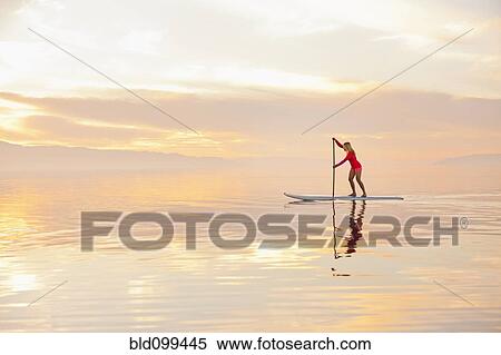 Caucasian woman standing on paddle board View Large Photo Image Stock Photography - Caucasian woman standing on paddle board. Fotosearch