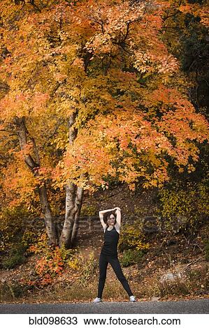 Caucasian woman stretching in autumn road View Large Photo Image Stock Image - Caucasian woman stretching in autumn road. Fotosearch