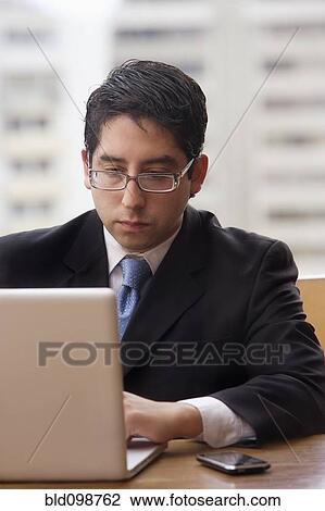 Stock Image - Chilean businessman using laptop. Fotosearch