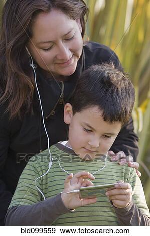 Stock Photo - Chilean mother and son listening to mp3 player together. Fotosearch