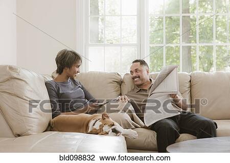Couple relaxing on sofa with English bulldog View Large Photo Image Stock Image - Couple relaxing on sofa with English bulldog. Fotosearch