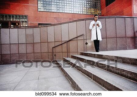 Picture - Doctor using digital tablet outdoors. Fotosearch