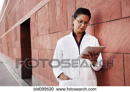 Stock Image - Doctor using digital tablet outdoors. Fotosearch