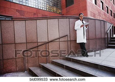 Stock Image - Doctor using digital tablet outdoors. Fotosearch
