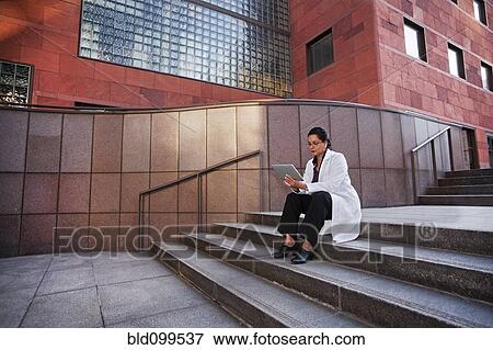 Stock Photo - Doctor using digital tablet outdoors. Fotosearch