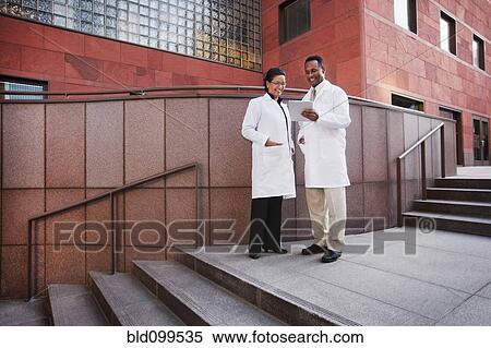 Stock Photography - Doctors using digital tablet outdoors. Fotosearch