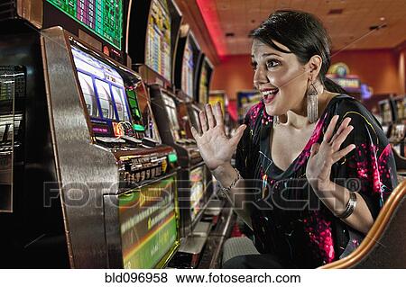 Excited Caucasian woman playing slot machines in casino View Large Photo Image Stock Photo - Excited Caucasian woman playing slot machines in casino. Fotosearch