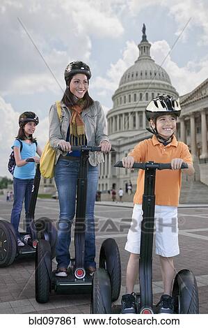 Stock Image - Family sightseeing together on segways. Fotosearch