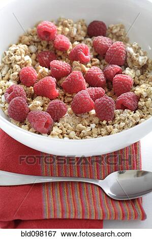 Stock Photo - Fresh raspberries in bowl granola cereal. Fotosearch